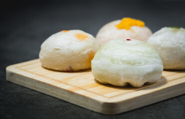 Traditional Chinese pastry on wooden plate against dark background for food and bakery concept