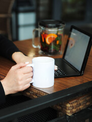 Young beautiful woman in a suit works with a laptop. Remote work concept.