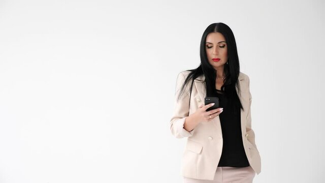 Confident Businesswoman walking on isolated white background holding mobile phone Business Woman texting Messages checking e-mail on Smartphone while the Walk. Success. Phones. Woman. Apps.