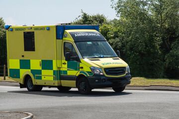 England UK.  Ambulance driving along a road to an emergency callout.
