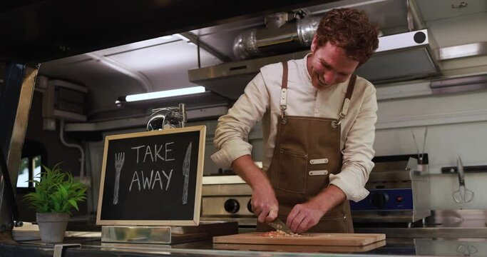Young chef man working inside food truck preparing dinner food - Summer job concept