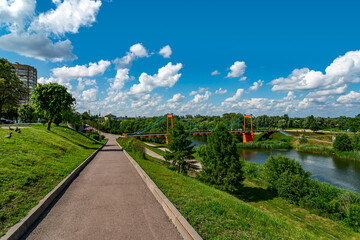 Fototapeta premium Beautiful view on Embankment of the Tsna River in Tambov. Suspension pedestrian bridge in Tambov city
