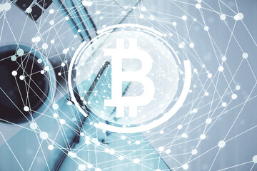Blockchain theme hologram drawings over computer on the desktop background. Top view. Multi exposure. Concept of cryptoeconomy.