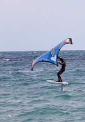 rider on a wind foil board, surf the waves