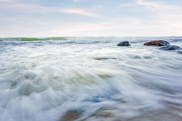 Baltic sea and sky. Big stone in the water - stormy weather. Long exposure.