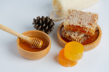 Natural skin care soap and serum with honey and honeycomb laid on white background.