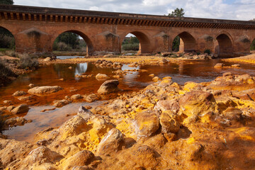 Obraz premium Dead red Tinto River with very acidic water as a result of the mining, in Huelva, Spain. Deep reddish hue is due to iron and copper dissolved in the water.