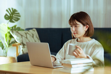 リビングでオンライン学習中の若い女性