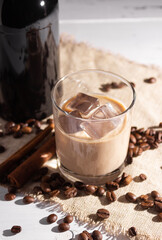 A glass of Irish cream coffee liqueur with ice and ice. Coffee beans, black bottle.