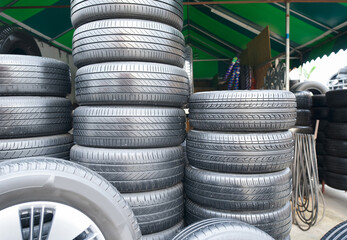 Several car tires are lined up in a tire shop.