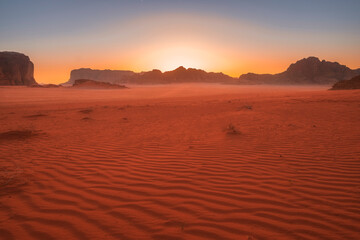 Beautiful sunset in the red desert of Wadi Rum in Jordan with patterns on the sand