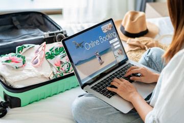 Young women planning summer vacation trip and searching information or booking hotel on laptop,...
