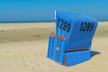 Roofed wicker beach chair at the coastline of North Sea infront of the ocean