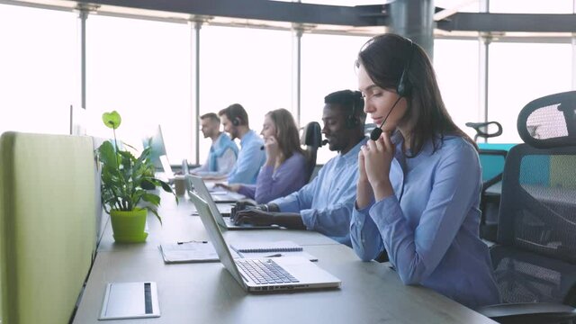 Contact center operator consulting clients in call center.