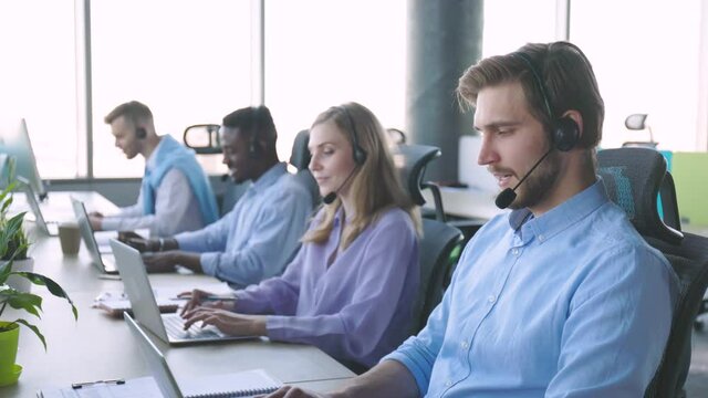Contact center operator consulting clients in call center.