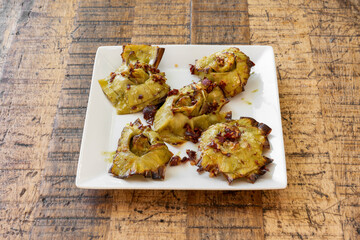 Typical Spanish dish of fried artichoke flowers with serrano ham cubes