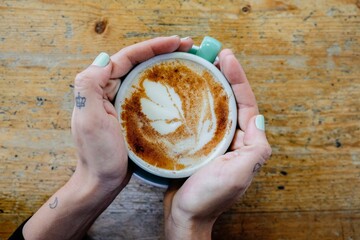 Woman holding a cup of soy latte 