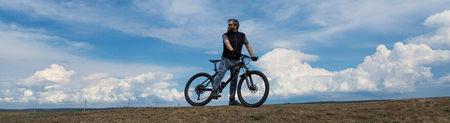 Fototapeta na wymiar Conquering mountain peaks by cyclist in shorts and jersey on a modern carbon hardtail bike with an air suspension fork .