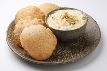 Shrikhand & Puri, Shrikhand is an Indian sweet dish made of strained curd, garnished with dry fruits and saffron. Served with Puri, Deep fried flat bread.
