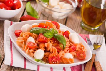 Fusilli pasta with cherry tomatoes and mozzarella cheese.