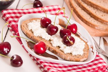 Rye bread with cottage cheese and cherries.
