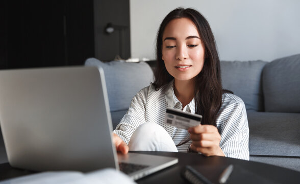 Image of young asian woman order online, shopping from home. Girl enter credit card info on webside to make purchase, using laptop to shop, paying bills with computer