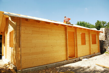 A partially constructed wood (fir) prefabricated block house on a domestic building site. The back...