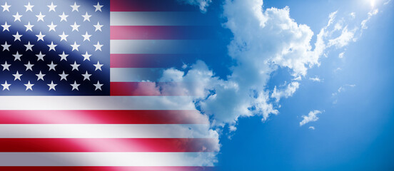 United States of America flag on the blue cloudy sky background.