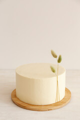 Minimalistic single tier wedding cake with white icing and decoration. Close up, copy space for text, background, top view.