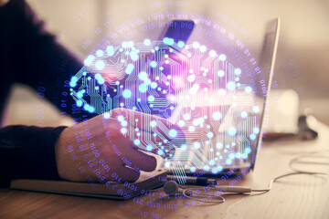 Double exposure of man's hand holding and using a digital device and brain hologram drawing. Data concept.