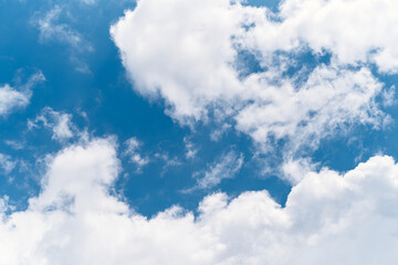 Naklejka na ściany i meble White clouds float across the bright blue sky. Close-up