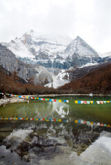 Nature scene of Landscape Pearl Lake with Chenrezig (Xiannairi) Holy Snow Mountain background at Yading winter season. It is beautiful green lake at yading national parks , daocheng china