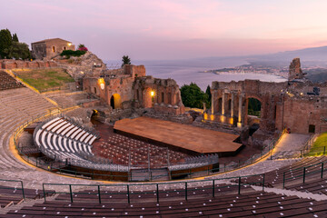 Sunset on the ancient roman-greek amphitheater with the Giardini Naxos bay in the back in Taormina,...