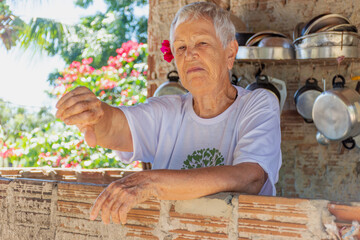 Mulher idosa em local simples aponta negativo