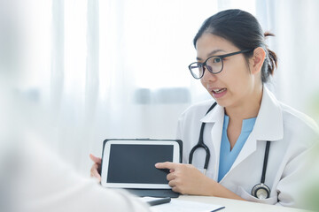 Asian Female Doctor or nurse using digital tablet in a meeting