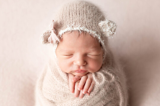 first newborn photo session. baby on a beige blanket in a hat with ears. portrait of a child