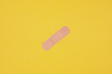 adhesive plaster tape or medical strip on yellow background