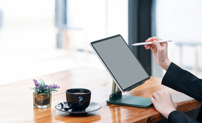 Cropped shot of woman hand using digital pen writing on tablet screen while working at office.