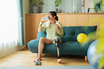 ストレッチ中に休憩する義足女性