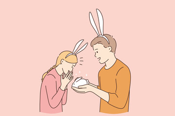 Funny cute present for girl concept. Young smiling boy cartoon character wearing rabbit ears giving white small rabbit gift for his surprised happy girlfriend vector illustration 