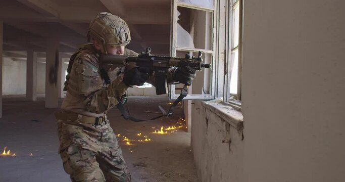 Modern warfare soldier in action near window changing magazine and take cover. Shooting trough a window in urban battlefield.