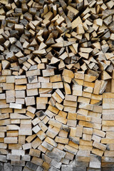 The vertical wall of stacked wood with different types of cut.