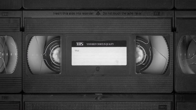 Vintage opening background of running VHS cassette amongst others, repeatable, with copy space, plus stylized VHS look