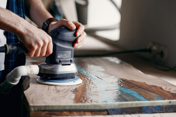 Man is processing with wood by polishing machine - obrazy, fototapety, plakaty