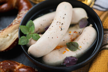 Close-up of a black bowl with weisswurst or munich white sausages served in bouillon, selective focus
