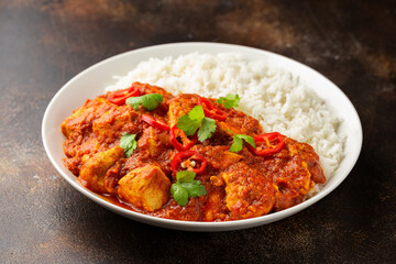 Spicy Chicken Pathia curry with basmati rice in a white plate. healthy food.