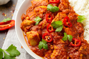 Spicy Chicken Pathia curry with basmati rice in a white plate. healthy food.