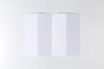 Empty sheet of paper folded four times on white background. Top view