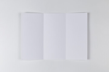 Empty sheet of paper folded three times on white background. Top view