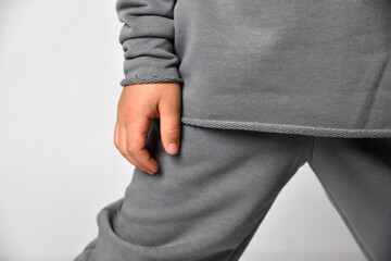 close-up view of a part of a comfortable kids casual suit in a sporty style, a soft cotton grey hoodie and pants.